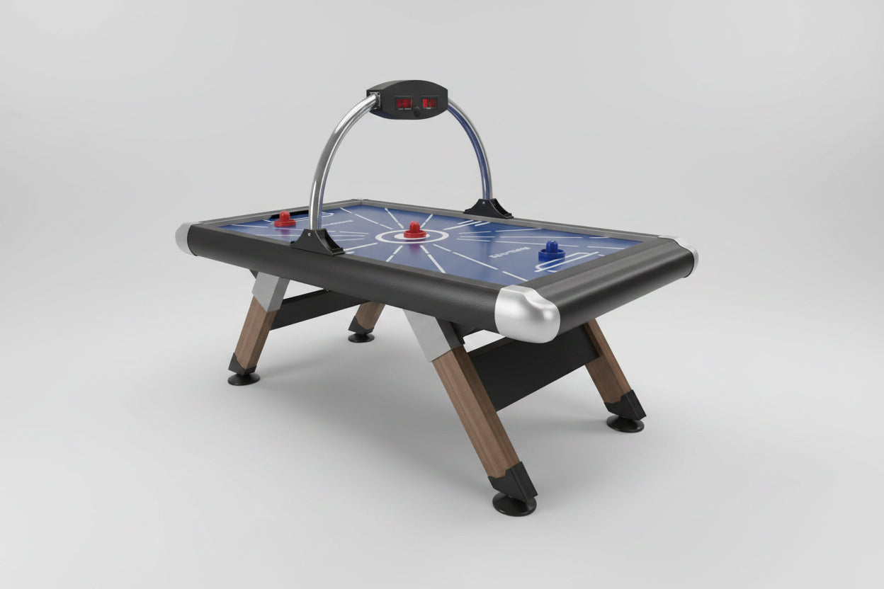 A dark blue and gray air hockey table with wooden legs, set in a brightly lit arcade shop with claw machines and other game tables in the background.
